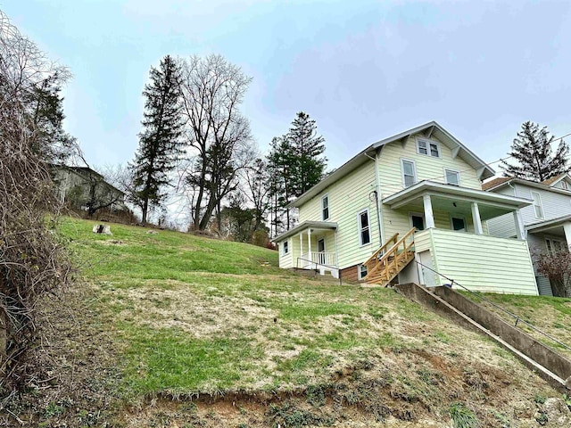 view of home's exterior featuring a yard and a porch