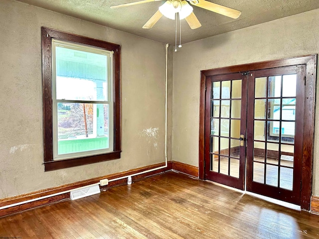 unfurnished room featuring french doors, plenty of natural light, and wood-type flooring