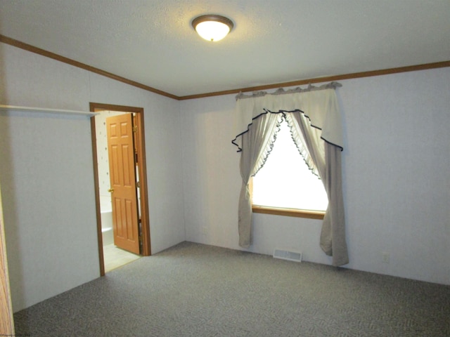 unfurnished room featuring a textured ceiling, crown molding, and light carpet