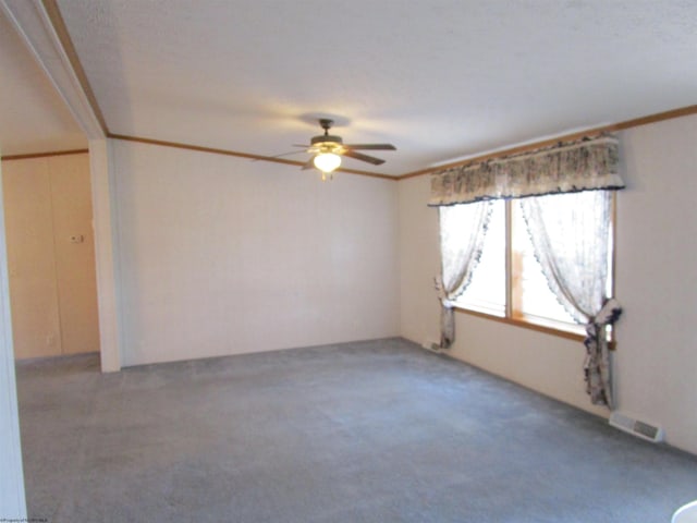 empty room with ceiling fan, carpet, and ornamental molding