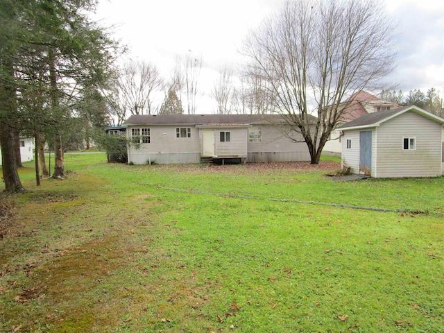 rear view of property featuring a storage shed and a lawn