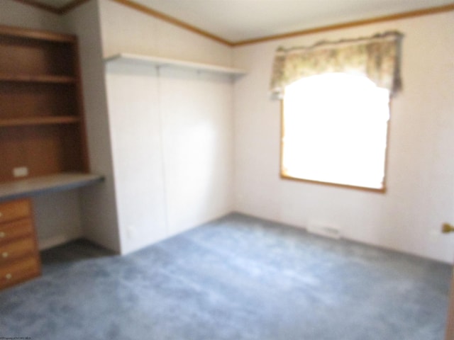 unfurnished bedroom featuring dark carpet, a closet, and crown molding