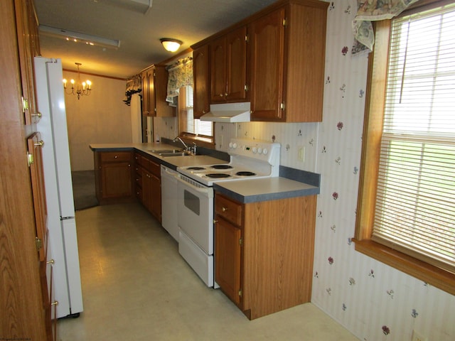 kitchen with white appliances, an inviting chandelier, and sink