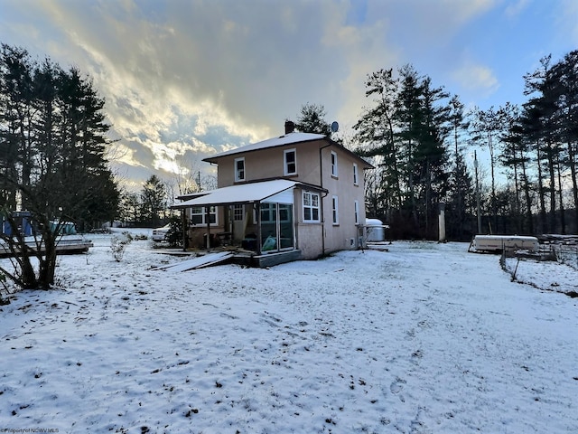 view of snow covered back of property