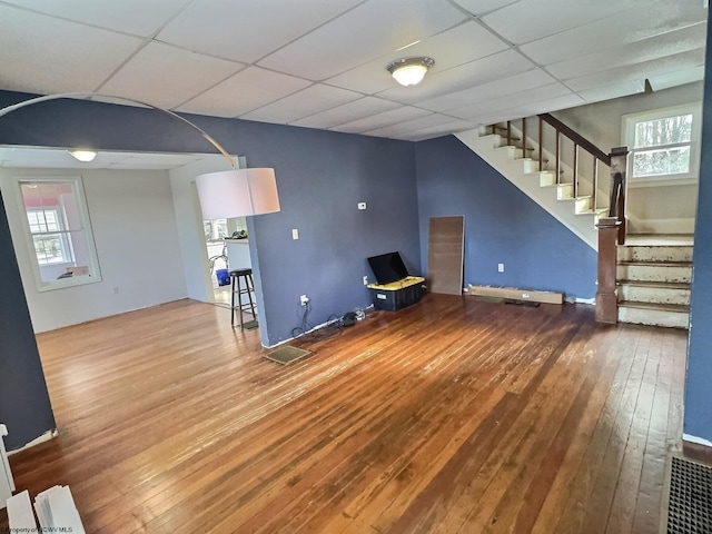 unfurnished living room featuring hardwood / wood-style flooring and a drop ceiling