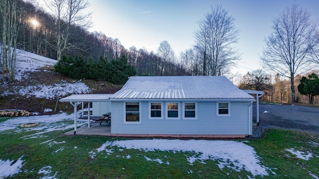 2302 Red Rock Rd, Rowlesburg, WV 26425 - snow covered rear of property with metal roof, a lawn, and a patio area