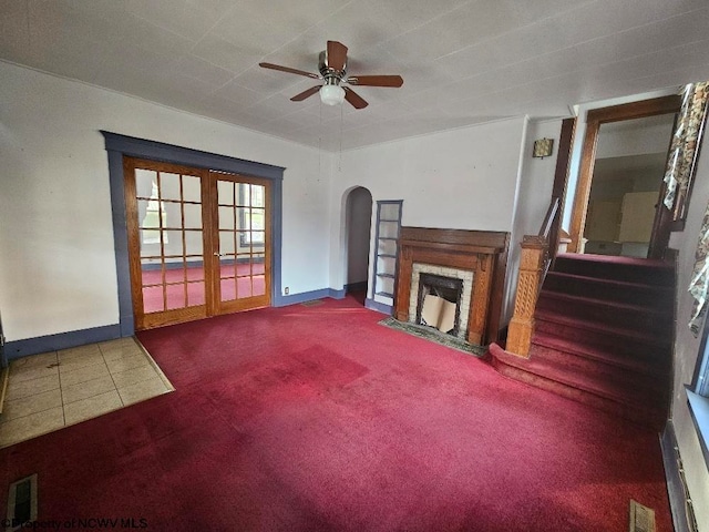 unfurnished living room featuring carpet, ceiling fan, and french doors