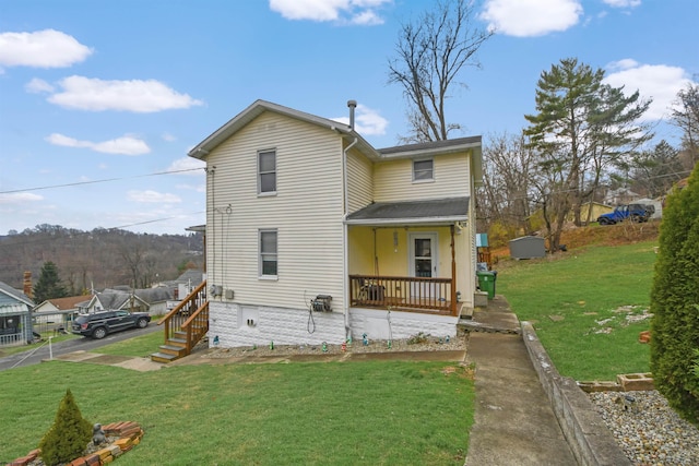 rear view of property with a yard and a porch