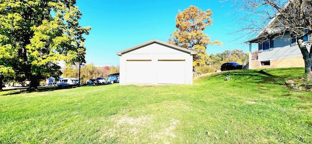 view of yard with a garage and an outbuilding