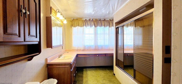 bathroom featuring combined bath / shower with glass door and vanity