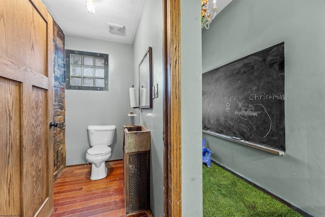 bathroom with hardwood / wood-style floors and toilet