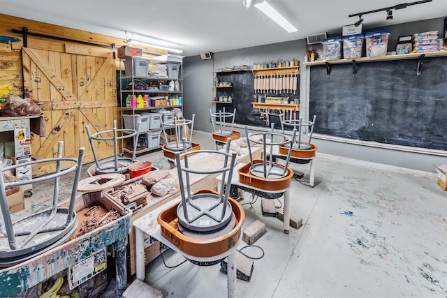 interior space featuring concrete flooring and a barn door