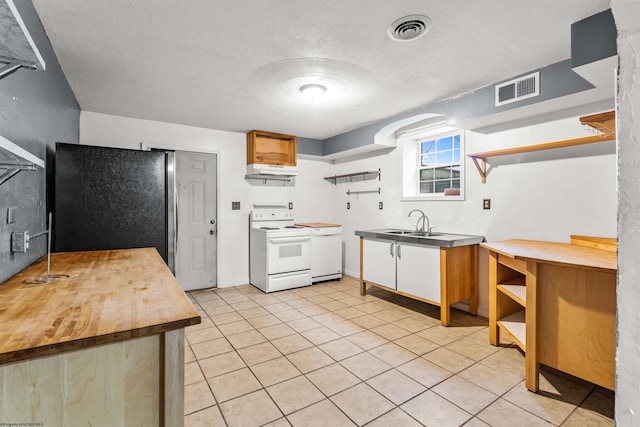 kitchen with white range with electric cooktop, black refrigerator, sink, a textured ceiling, and light tile patterned flooring