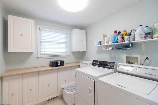 laundry area featuring cabinets, independent washer and dryer, and light tile patterned flooring