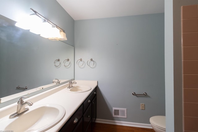 bathroom with vanity, wood-type flooring, and toilet