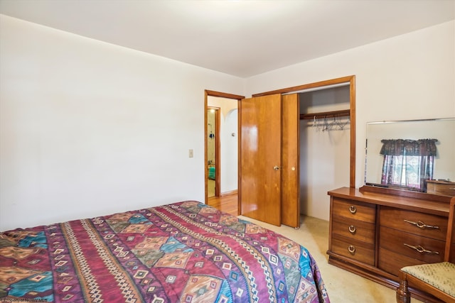 bedroom with light colored carpet and a closet