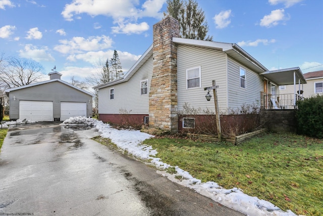 view of front of home featuring a front yard, an outdoor structure, and a garage