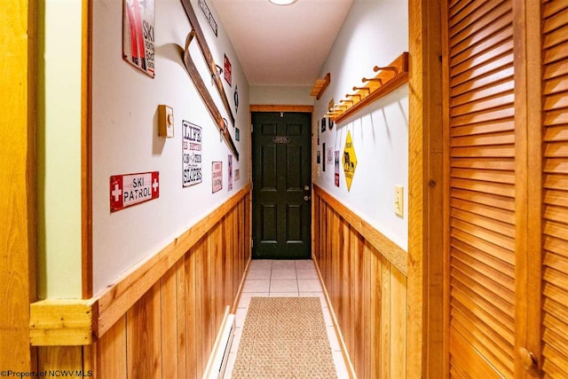 hall featuring wood walls and light tile patterned flooring