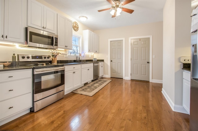 kitchen with white cabinetry, sink, light wood-type flooring, and appliances with stainless steel finishes