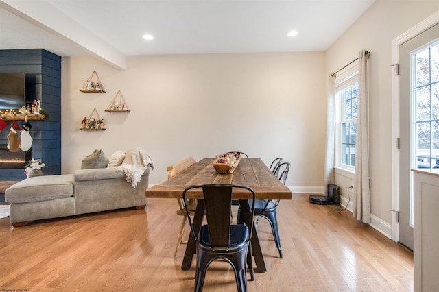 dining space featuring beam ceiling and light wood-type flooring