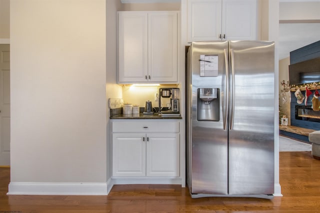 kitchen featuring hardwood / wood-style flooring, white cabinets, and stainless steel refrigerator with ice dispenser