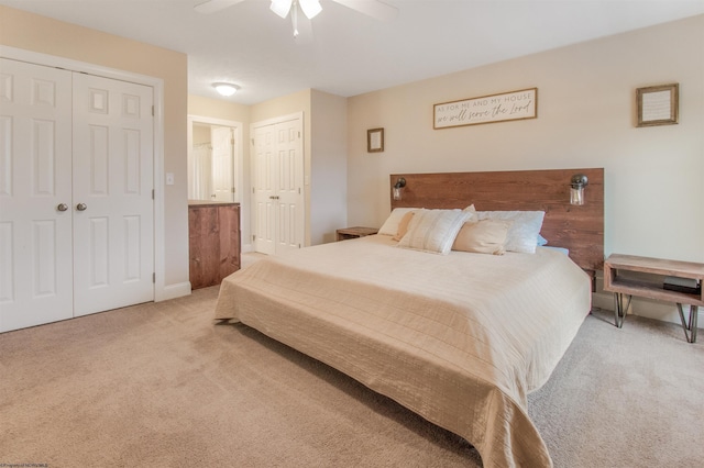 carpeted bedroom featuring ceiling fan and two closets