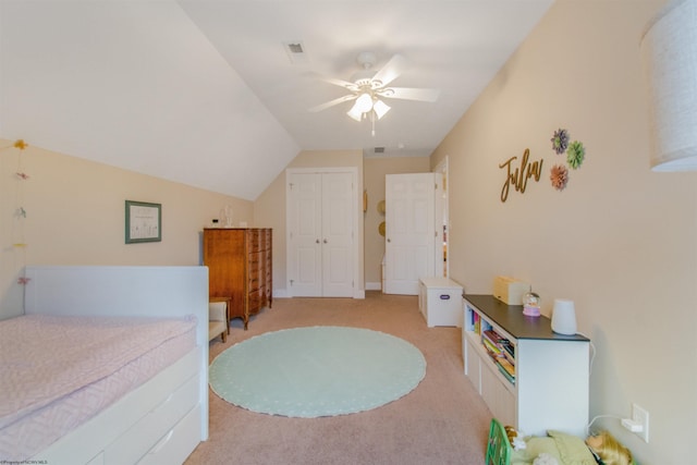 carpeted bedroom with ceiling fan, a closet, and vaulted ceiling