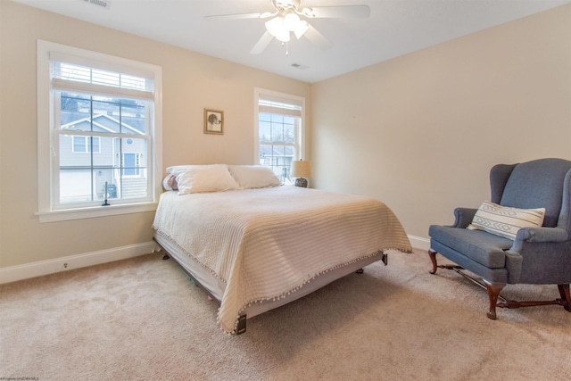 carpeted bedroom featuring ceiling fan and multiple windows