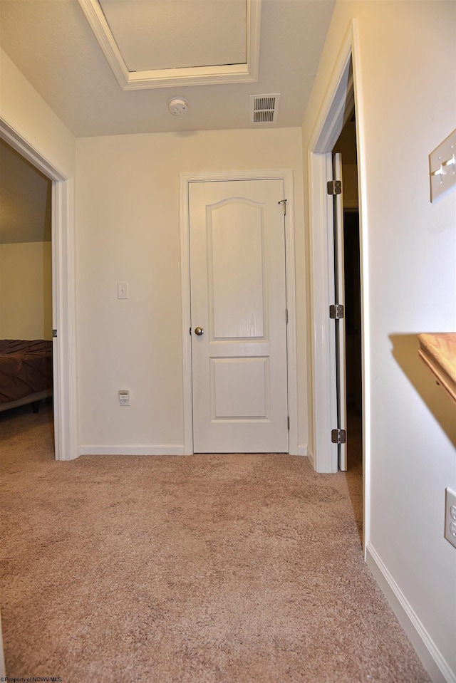 hallway featuring light colored carpet