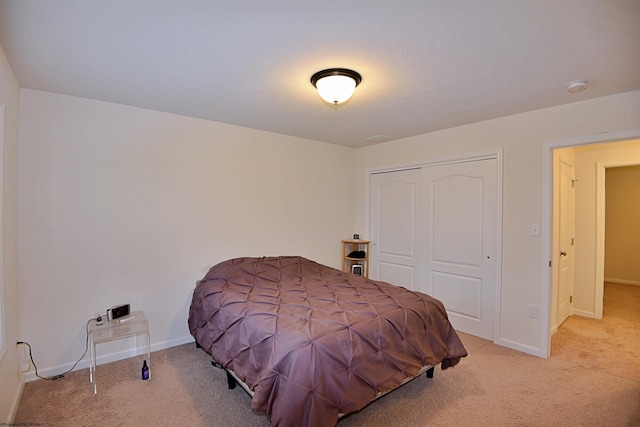 bedroom featuring light carpet and a closet