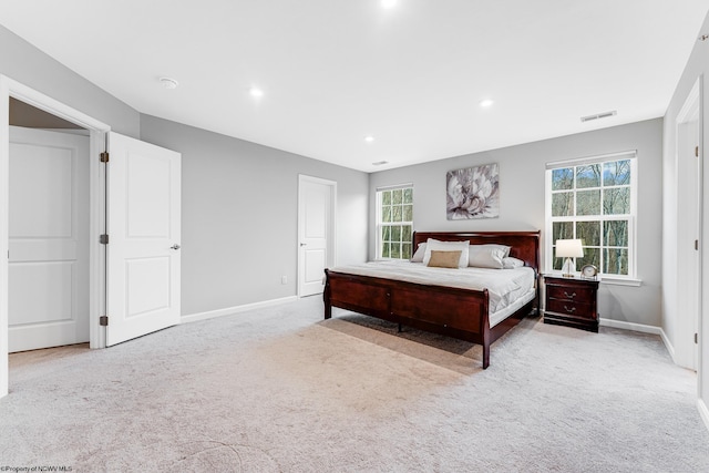 bedroom featuring multiple windows and light colored carpet