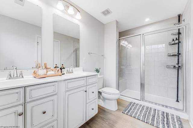 bathroom featuring vanity, hardwood / wood-style flooring, toilet, and walk in shower