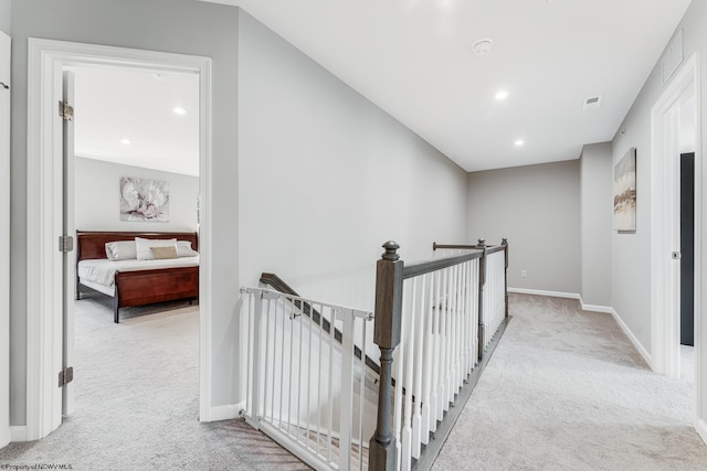 hall with light colored carpet