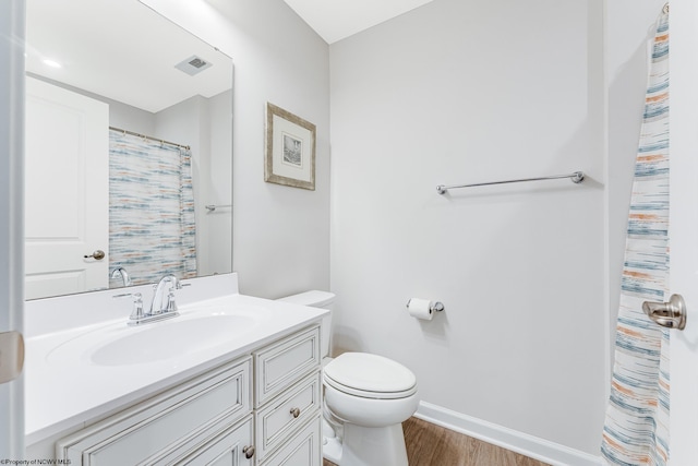 bathroom with toilet, vanity, and hardwood / wood-style flooring