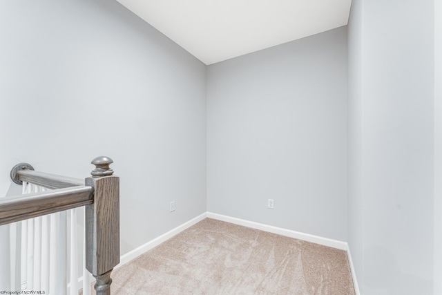 carpeted empty room with lofted ceiling