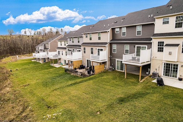 rear view of property featuring a patio area, a yard, and central AC unit