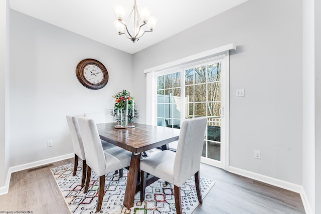 dining area featuring a notable chandelier and hardwood / wood-style flooring