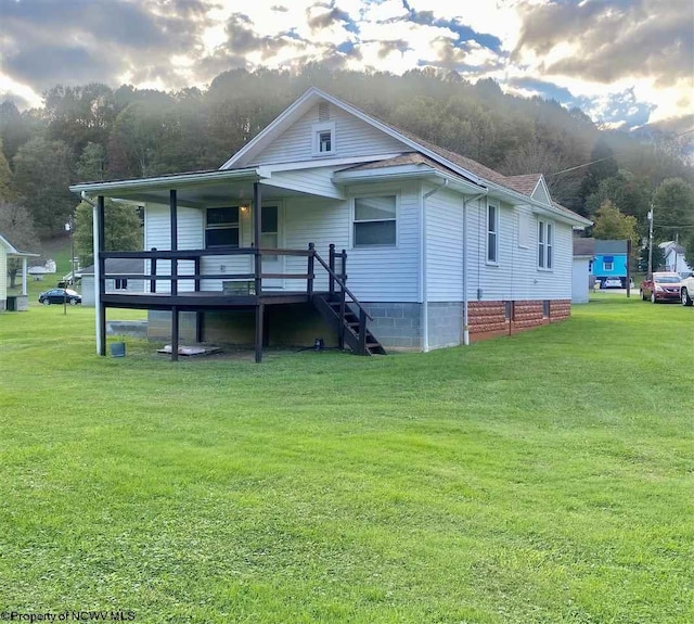 view of front facade featuring a wooden deck and a front lawn