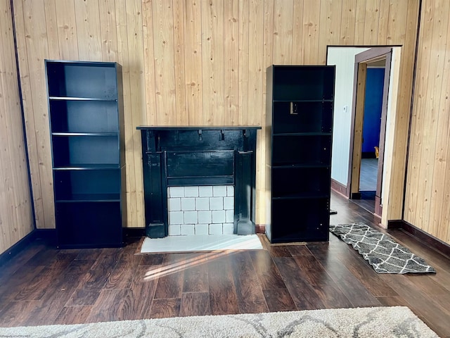 unfurnished living room featuring wood walls and dark hardwood / wood-style flooring