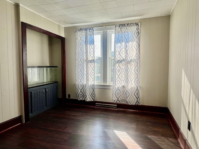 spare room featuring dark hardwood / wood-style floors and radiator heating unit