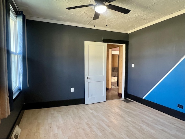 unfurnished room with crown molding, ceiling fan, a healthy amount of sunlight, and light hardwood / wood-style floors