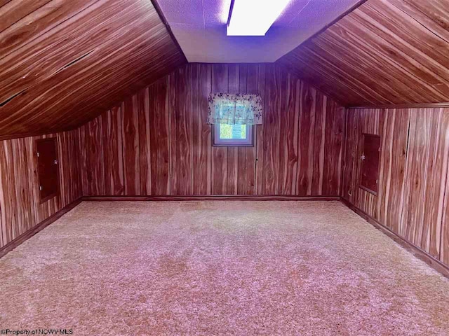 bonus room featuring light carpet, wooden walls, and vaulted ceiling