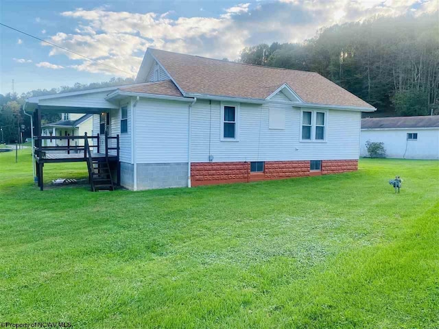 view of side of property with a lawn and a wooden deck