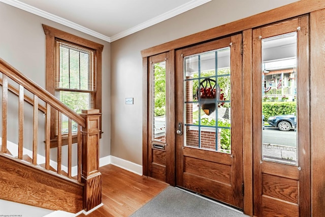 entrance foyer with a wealth of natural light, crown molding, french doors, and light wood-type flooring