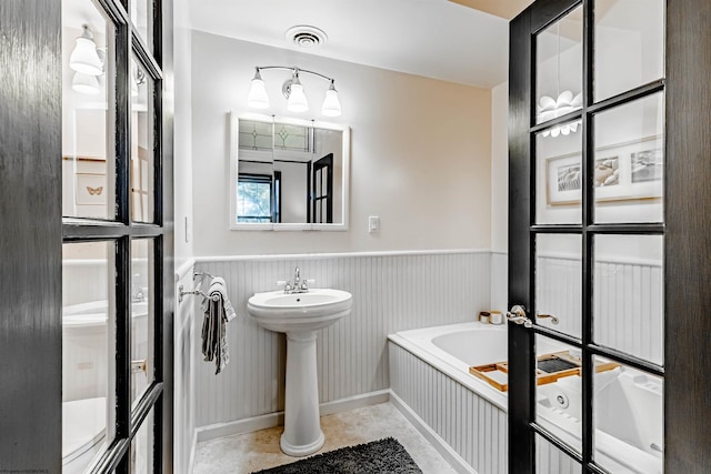 bathroom with a tub to relax in and sink