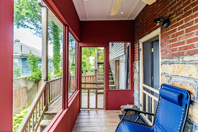 unfurnished sunroom with ceiling fan