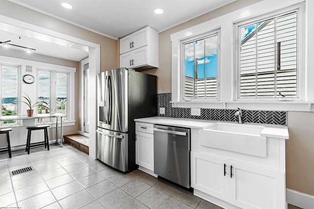 kitchen with white cabinetry, sink, decorative backsplash, light tile patterned flooring, and appliances with stainless steel finishes