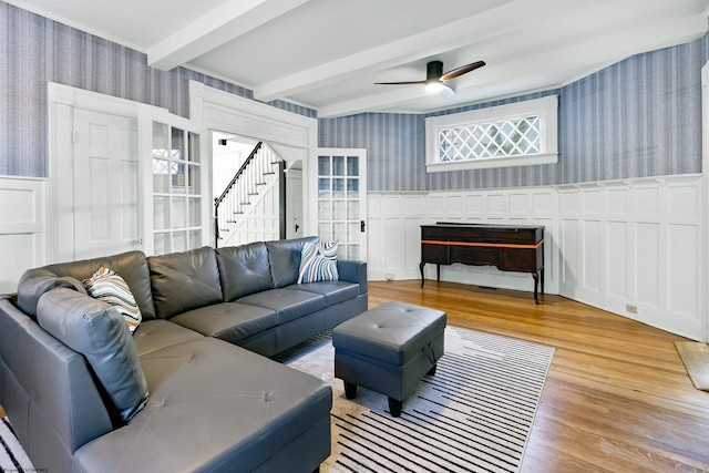 living room featuring beamed ceiling, ceiling fan, and hardwood / wood-style flooring