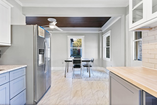 kitchen with stainless steel refrigerator with ice dispenser, white cabinetry, ceiling fan, and crown molding