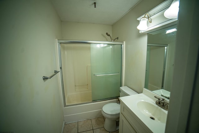 full bathroom featuring tile patterned flooring, vanity, toilet, and combined bath / shower with glass door